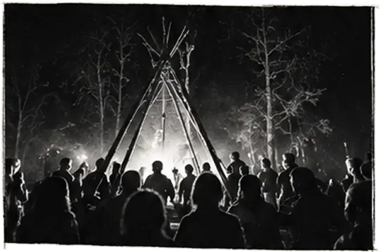Circle gathered around a fire beneath a tipi at night